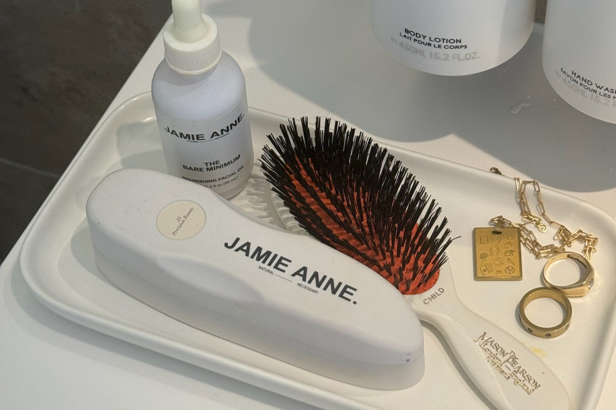 The Roller and The Bare Minimum with a hair brush on a skincare ceramic tray