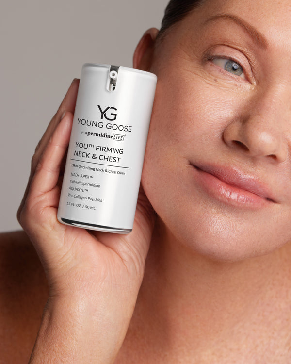 Model holding a full size Young Goose Youth Firming Neck and Chest Cream #50ml